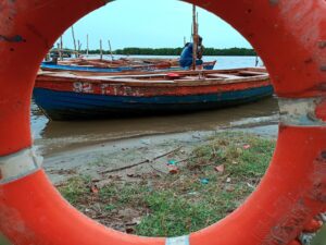 Deva Vikaas (This photograph reveals the role of contemplation on life by a boatman. This prompts us to think about the circular nature of life across generations. It is shown indirectly through the circular frame created by the Ring life-buoy. Additionally, it espouses the priceless beauty of mangrove forests. They are not only important for the environment through their oxygen production, prevention of soil erosion, mitigating effects of tsunamis, etc. but also for their significance for tourist sector (Eco-tourism) and aesthetics The location of the photograph is Killai, Chidambaram, Tamil Nadu.)